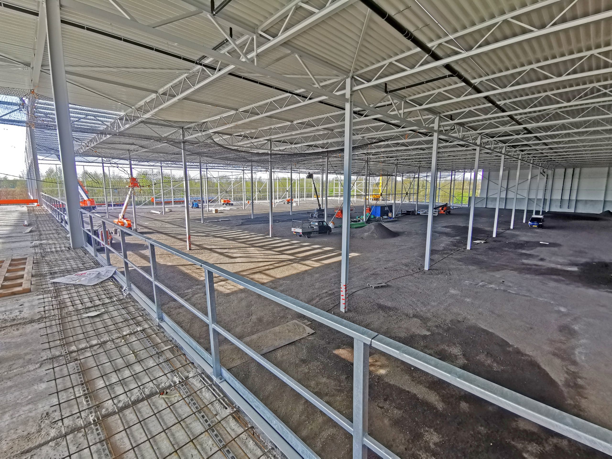 Grote hal in aanbouw met metalen constructie.