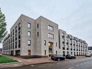 Modern gebouw met geparkeerde auto's ervoor.