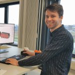 vericon joost van dinteren Man werkt aan computer met bouwontwerp op scherm.